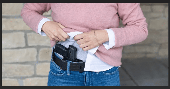 a girl with concealed carry inside the waist band with jeans on