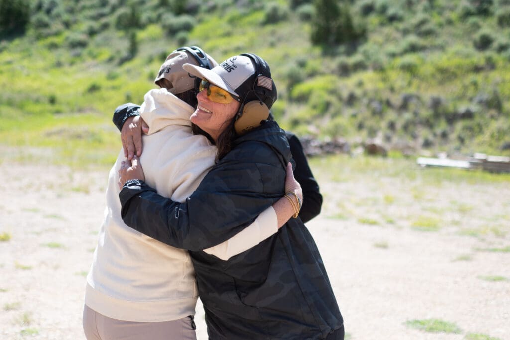two women hugging at the range